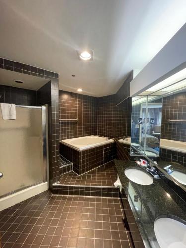 a bathroom with two sinks and a bath tub at Apm Inn & Suites in Hagerstown