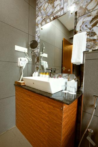 a bathroom with a white sink and a mirror at Au Revoir Wellness Resort, Malampuzha in Palakkad