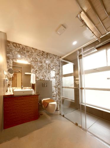 a bathroom with a toilet and a sink and a mirror at Au Revoir Wellness Resort, Malampuzha in Palakkad