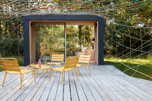 a patio with a table and chairs on a deck at La Belle Folie in Ploemel