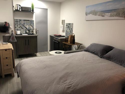 une chambre avec un lit et un bureau dans l'établissement Studio à 50 m de la mer avec parking privatif, à Saint-Hilaire-de-Riez