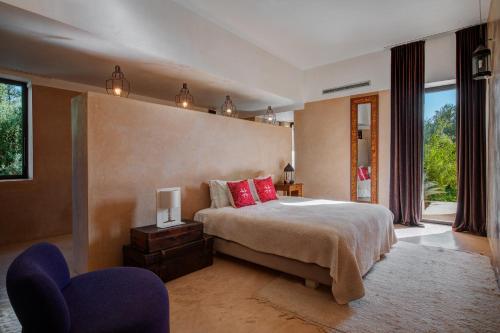 een slaapkamer met een groot bed met rode kussens bij Pavillon Terra Ababila en Exclusivité in Marrakesh