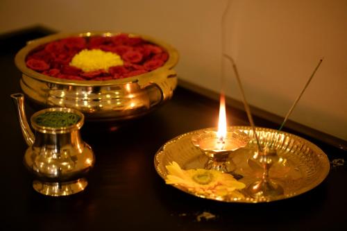 a table with a candle and a bowl of flowers at Au Revoir Wellness Resort, Malampuzha in Palakkad