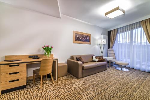 a living room with a couch and a desk in a room at Rezydencja Nosalowy Dwór in Zakopane