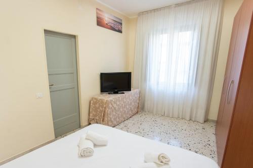 ein Hotelzimmer mit einem Bett und einem TV in der Unterkunft Appartamenti Leonarda in Trapani