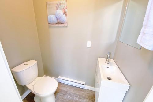 uma casa de banho com um WC branco e um lavatório. em Woodland Cabins Micro Resort em Sorrento