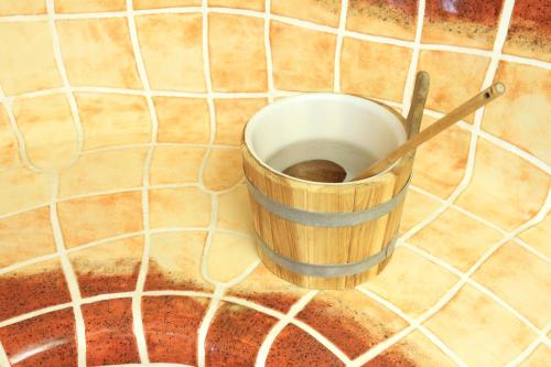 a bucket on the floor with a wooden spoon at Hotel Der Stockinger in Premstätten