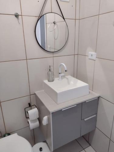 a bathroom with a sink and a mirror and a toilet at Casa de Férias in Florianópolis