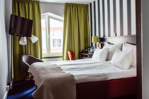 a hotel room with a bed and a television at ProfilHotels Calmar Stadshotell in Kalmar