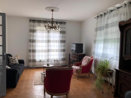 a living room with a couch and chairs and a tv at Coalpie in Barbaste