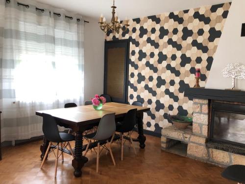 Coalpie في Barbaste: غرفة طعام مع طاولة وكراسي ومدفأة