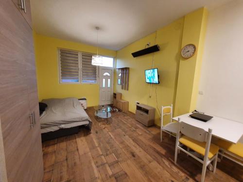 a bedroom with yellow walls and a desk and a bed at Apartmani Sarti Banja Luka in Banja Luka