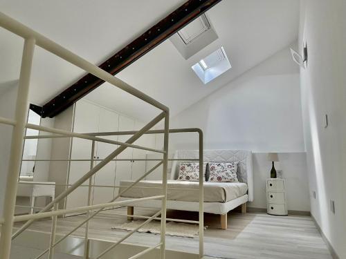 a white bedroom with a bed and a staircase at Senigallia Loft La ContEsSa in Senigallia