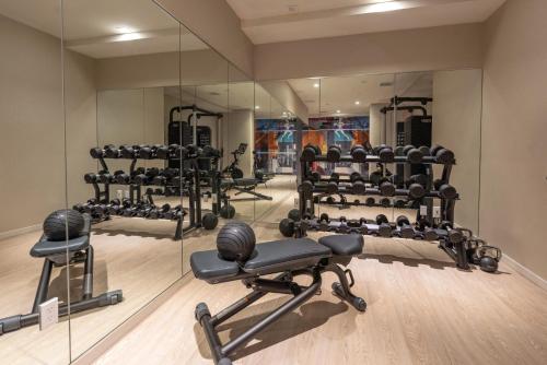 - une salle de sport avec de nombreux équipements et miroirs dans l'établissement Pestana CR7 Times Square, à New York