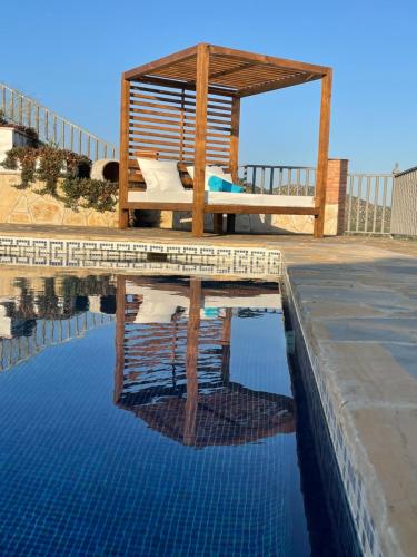 a wooden gazebo sitting next to a swimming pool at El Mirador in Iznájar