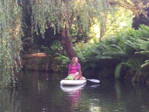 a woman is sitting on a paddle board in the water at Doppelzimmer im Spreewald in Burg