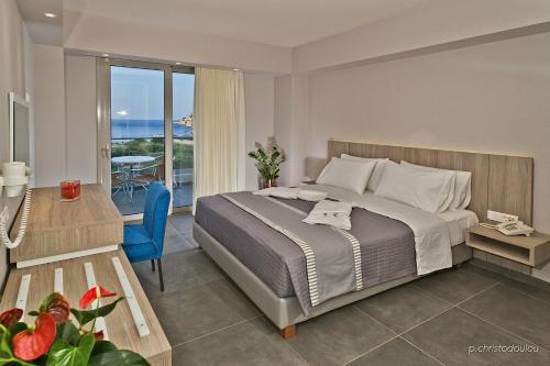 Parasol Luxury Hotel & Suites Adults Only في كارباثوس: غرفة نوم مع سرير وإطلالة على المحيط