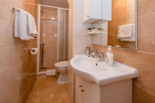 a bathroom with a sink and a toilet and a shower at Apartment in Mundanije with Seaview, Terrace, Air condition, WIFI (3748-3) in Mundanije