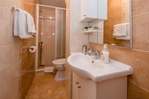 ein Badezimmer mit Waschbecken, Toilette und Dusche in der Unterkunft Apartment in Mundanije with Seaview, Terrace, Air condition, WIFI (3748-3) in Mundanije
