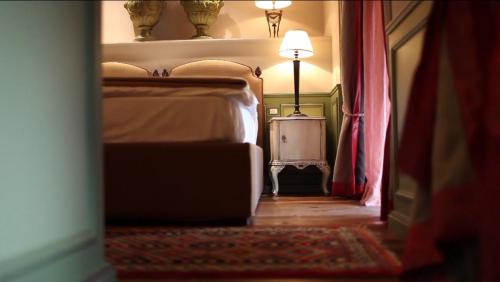 a bedroom with a bed and a table with a lamp at Il Relais in Verona
