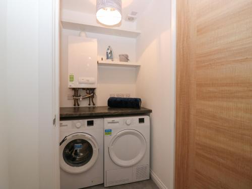 a small laundry room with a washer and dryer at Ocean View in Banff
