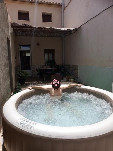 a person in a hot tub in a backyard at Casa Rural Rectoría de Raspay in Raspay