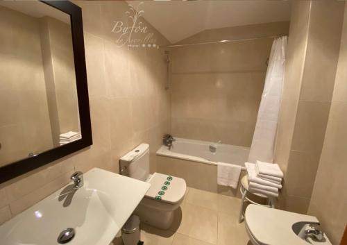 a bathroom with a toilet, sink, and bathtub at Hotel Bufon de Arenillas in Vidiago