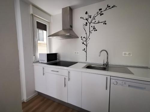 a kitchen with white cabinets and a sink and a window at IMEDA REYES CATÓLICOS in Granada