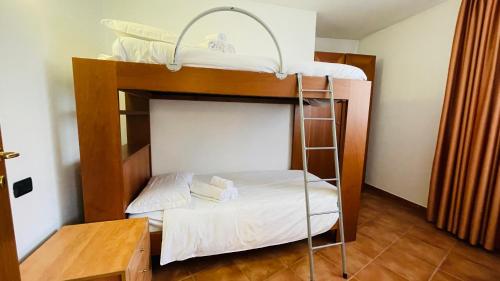 two bunk beds in a room with a table at Appartamento Smith Roero - Affitti Brevi Italia in Bardonecchia