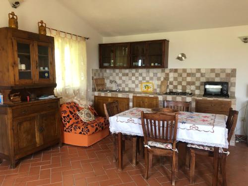 - une cuisine avec une table et des chaises dans la chambre dans l'établissement Monolocale La Mimosa, à Elmo