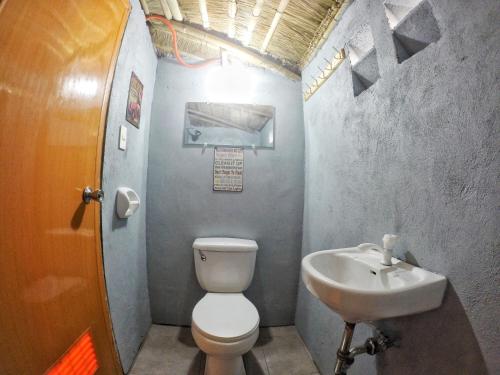 a small bathroom with a toilet and a sink at Faith Bay Huts in Camiing