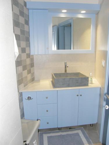 a bathroom with a sink and a mirror at The Water Mill Cottage in Lagoúdi Zía