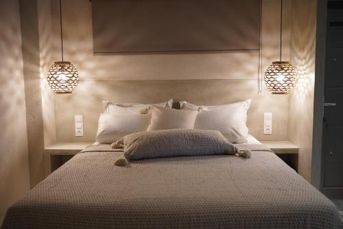 a bedroom with a large bed with two lights on it at Alterra Vita Eco Villas in Neos Marmaras