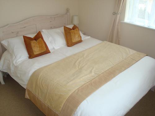 a white bed with two pillows on top of it at Riverside Apartment in Launceston