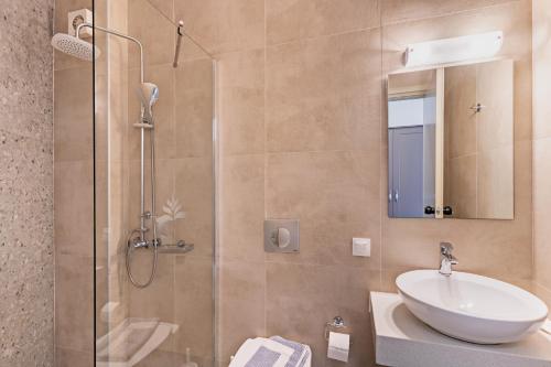 a bathroom with a sink and a glass shower at Hotel Kathrin Beach in Adelianos Kampos
