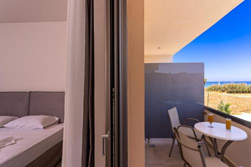 a bedroom with a bed and a table with a table at Hotel Kathrin Beach in Adelianos Kampos