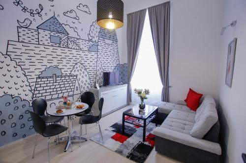 a living room with a couch and a table and chairs at Uránia Apartmanház in Eger