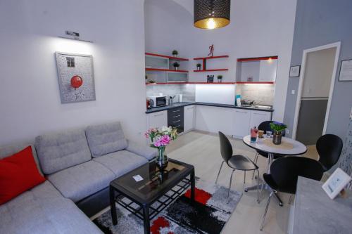 a living room with a couch and a table and a kitchen at Uránia Apartmanház in Eger