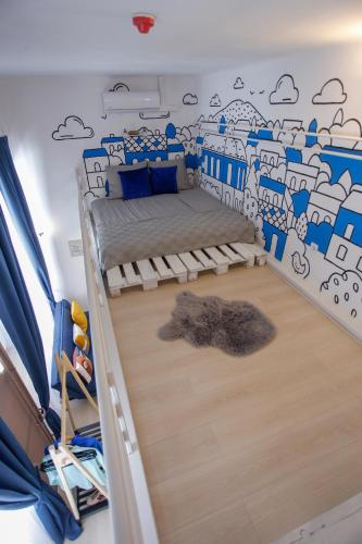 a bedroom with a bed and a wall with clouds at Uránia Apartmanház in Eger