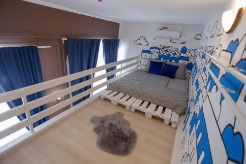 a bedroom with a bed with blue and white walls at Uránia Apartmanház in Eger