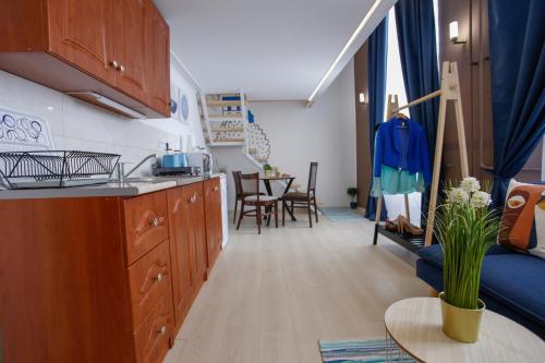a kitchen and living room with a couch and a table at Uránia Apartmanház in Eger