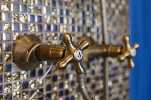 a bronze water faucet with a number on it at Uránia Apartmanház in Eger
