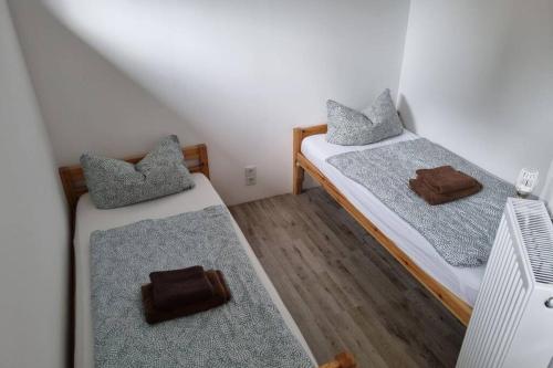 two twin beds in a small room with wooden floors at Ferienwohnung/Monteurwohnung Alte Garage in Weimar