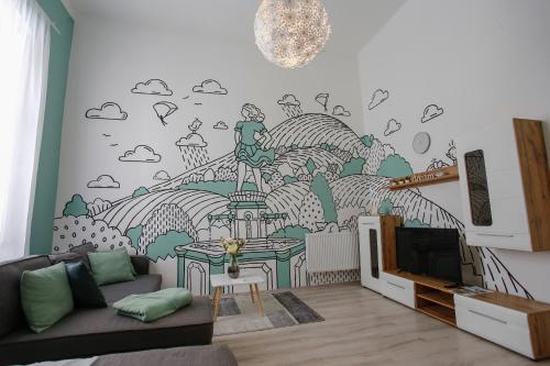 a living room with a tv and a wall mural at Uránia Apartmanház in Eger