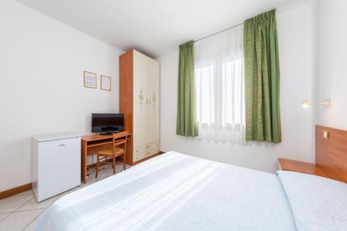a bedroom with a bed and a desk and a television at Hotel New Aurora Venice in Marghera