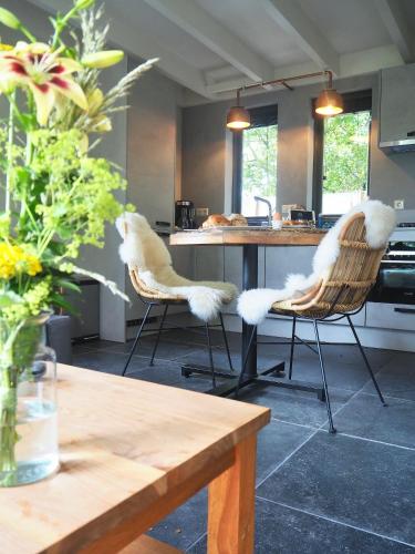 a kitchen with two chairs with white fur at Zilt7 in Callantsoog