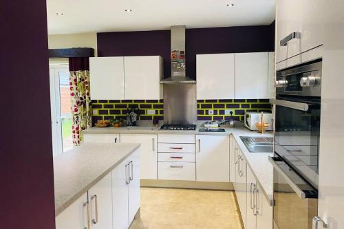 a kitchen with white cabinets and white appliances at Spacious home for contractors and families in Sherborne Saint John