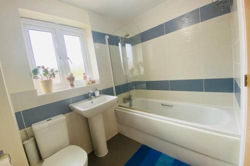 a bathroom with a toilet and a sink and a bath tub at Spacious home for contractors and families in Sherborne Saint John