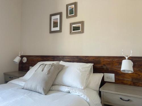 a white bed with white pillows and a wooden headboard at Fonda Peremiquel in Castellar de NʼHug