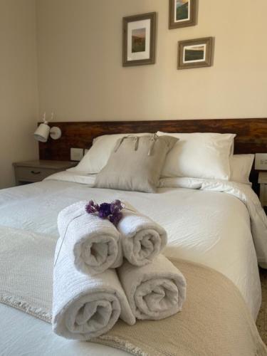 a white bed with towels on top of it at Fonda Peremiquel in Castellar de NʼHug